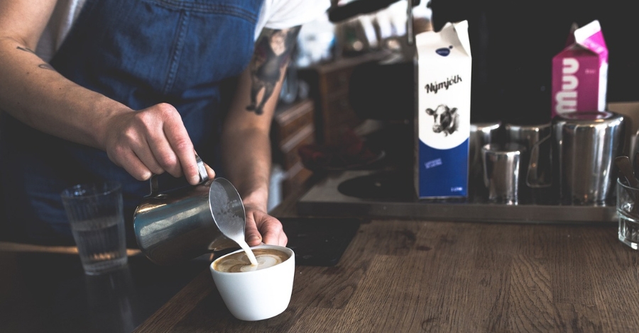 Imagem de uma pessoa servindo café com leite - alimento com lactose